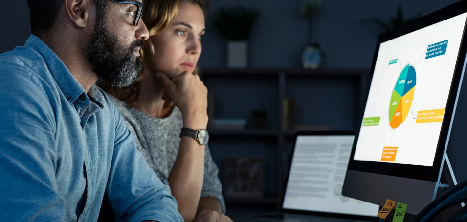 People looking at a graph on a desktop