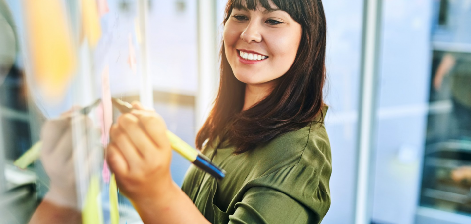 Lady writing on board with sticky notes