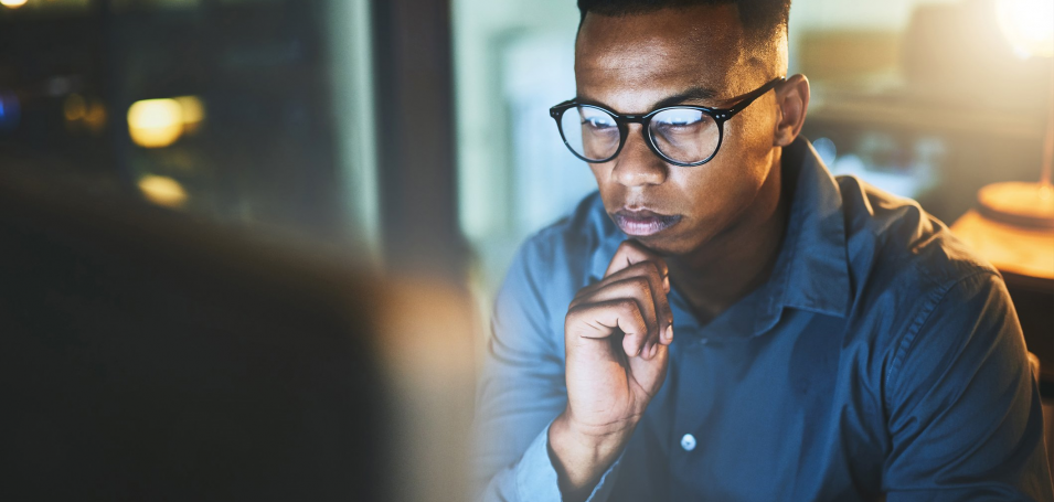 Man with computer screen reflecting on his face