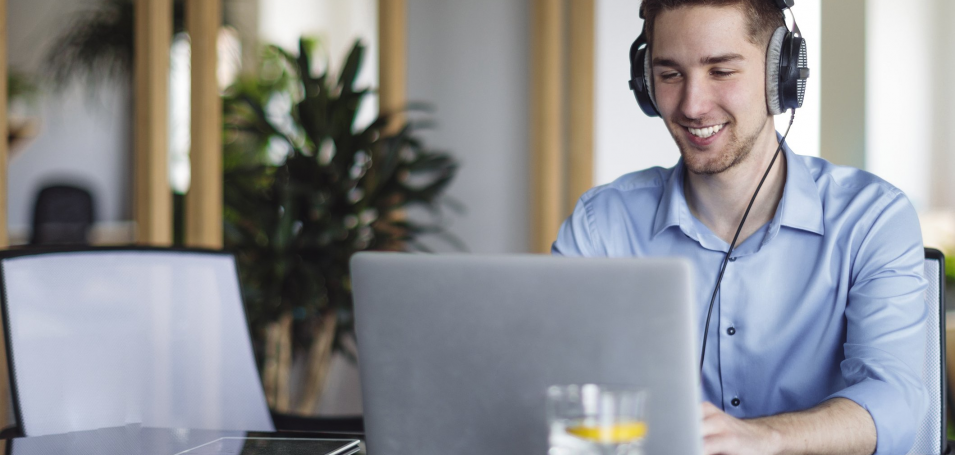 Man on computer with headphones on