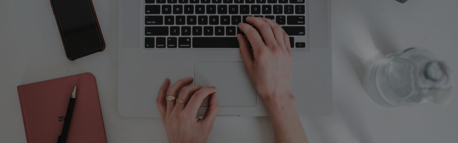 Hands typing on a laptop