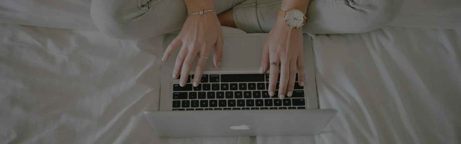 Hands typing on a laptop