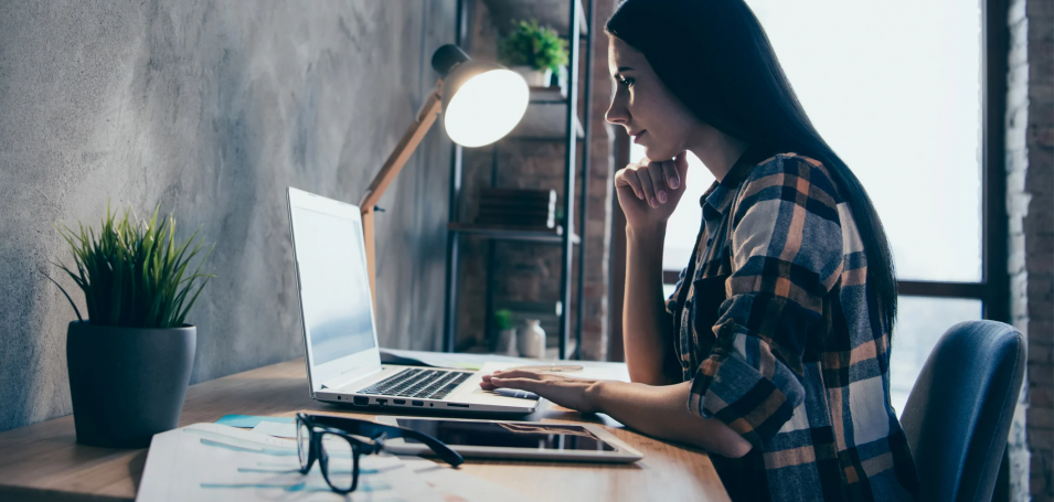 Woman sitting at a desk looking at a laptop