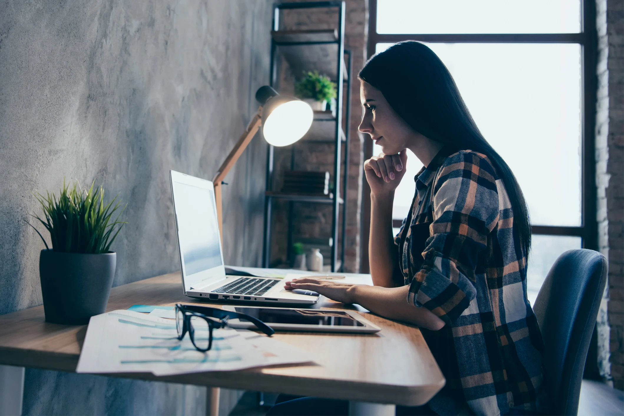 Woman sitting at a desk looking at a laptop