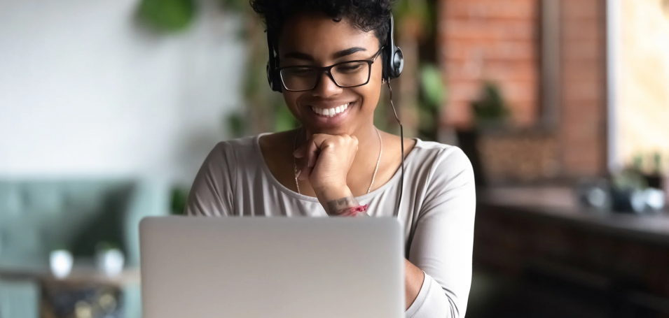 Lady on a computer with headphones on