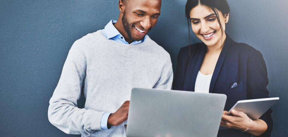 A man and woman looking at a laptop screen